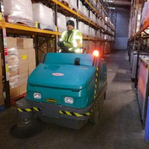 Magnum Ride On Sweeper cleaning a warehouse floor
